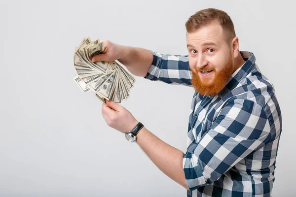 Людина з бородою тримає багато стодоларових купюр — стокове фото