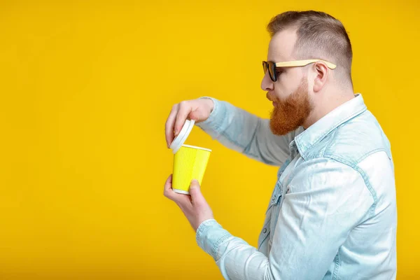 red beard man holding cup with coffee