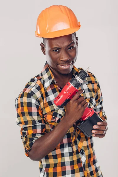 Afrikaanse Amerikaanse arbeider gebruikt elektrische schroevendraaier — Stockfoto