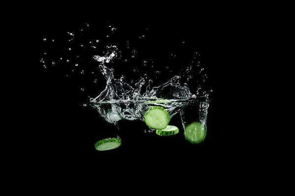 Komkommer in water met splash — Stockfoto