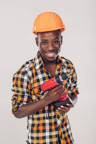 Trabalhador afro-americano usa chave de fenda elétrica — Fotografia de Stock