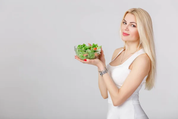 Femme en robe blanche avec salade fraîche — Photo