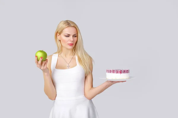 Mujer elige entre pastel y manzana —  Fotos de Stock