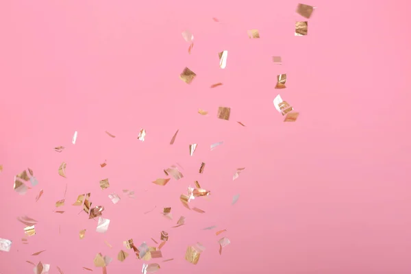 Golden konfetti på rosa bakgrund — Stockfoto