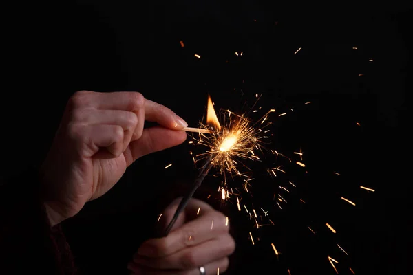 Manos femeninas sosteniendo luz bengala . — Foto de Stock