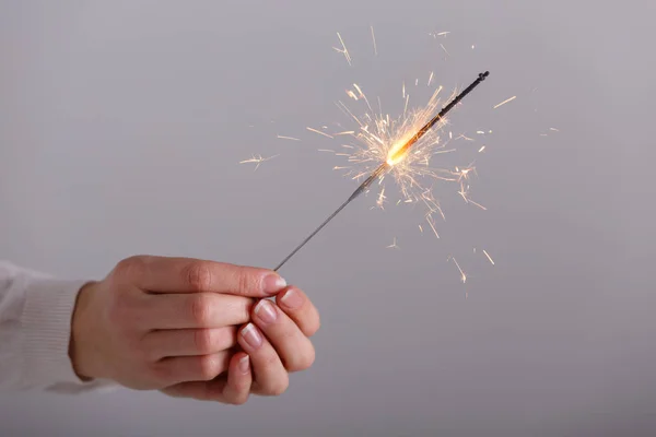 Manos femeninas sosteniendo luz bengala . — Foto de Stock