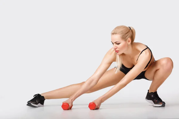 Mulher em sportswear faz exercícios — Fotografia de Stock