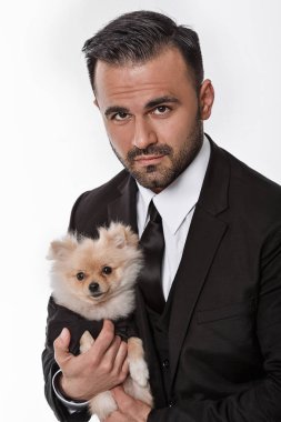 siyah elbiseli adam pomeranian köpek tutar