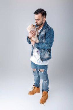 kot ceketli adamı pomeranian köpek tutar.