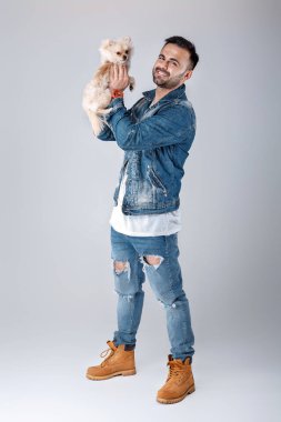kot ceketli adamı pomeranian köpek tutar.