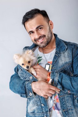 kot ceketli adamı pomeranian köpek tutar.