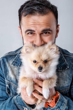 kot ceketli adamı pomeranian köpek tutar.