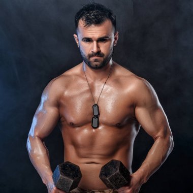 kaslı adam dumbbells ile yapıyor.