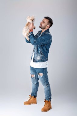 kot ceketli adamı pomeranian köpek tutar.