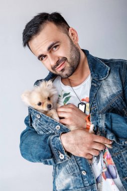 kot ceketli adamı pomeranian köpek tutar.