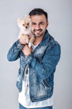kot ceketli adamı pomeranian köpek tutar.