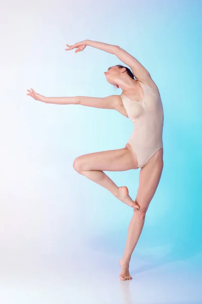 Стройная гимнастка в бежевом купальнике — стоковое фото