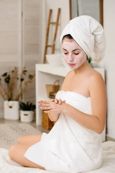 Woman is applying mask on her face — Stock Photo, Image