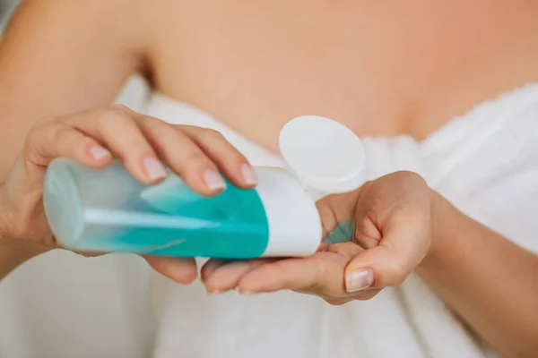 Las manos de las mujeres sostienen tónico para eliminar el maquillaje. — Foto de Stock