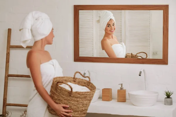 Woman holding wicker basket with laundry — Stockfoto