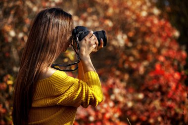 Kadın fotoğrafçı kamera tutuyor