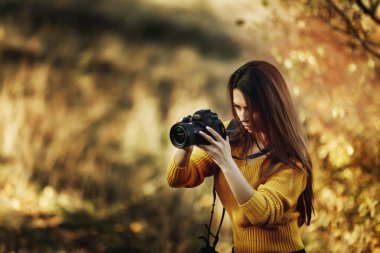Kadın fotoğrafçı kamera tutuyor