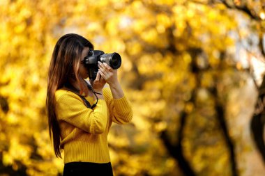 Kadın fotoğrafçı kamera tutuyor