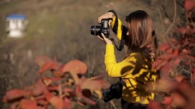 Kadın fotoğrafçı kamerayla fotoğraf çekiyor..