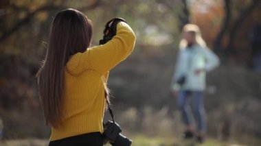 Kadın fotoğrafçı kamerayla fotoğraf çekiyor..