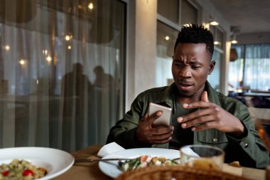 Kafede dizüstü bilgisayar kullanan Afrikalı genç bir Amerikalı.