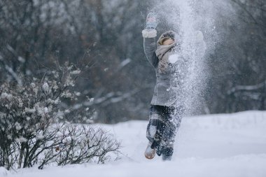 sevimli küçük kız kış ormanda. kar yağışı