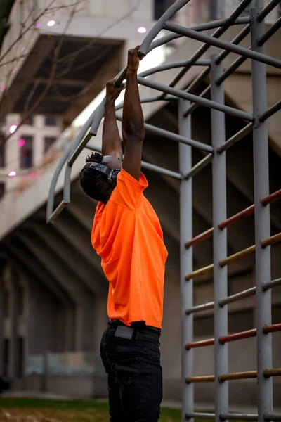 Uomo afro-americano tirarsi su su su su barre orizzontali — Foto Stock