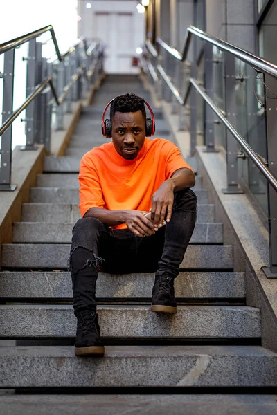 Hombre afroamericano en auriculares inalámbricos escuchando música — Foto de Stock