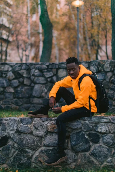 Hombre afroamericano en auriculares inalámbricos escuchando música — Foto de Stock