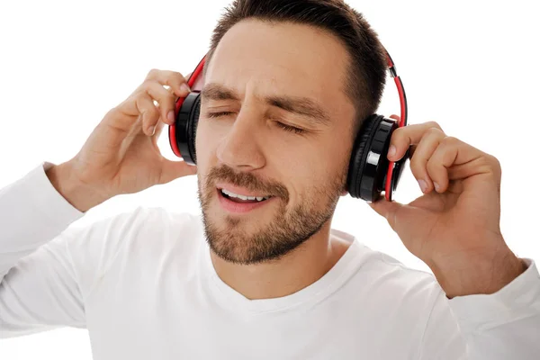 Ung man i hörlurar lyssnar på musik — Stockfoto
