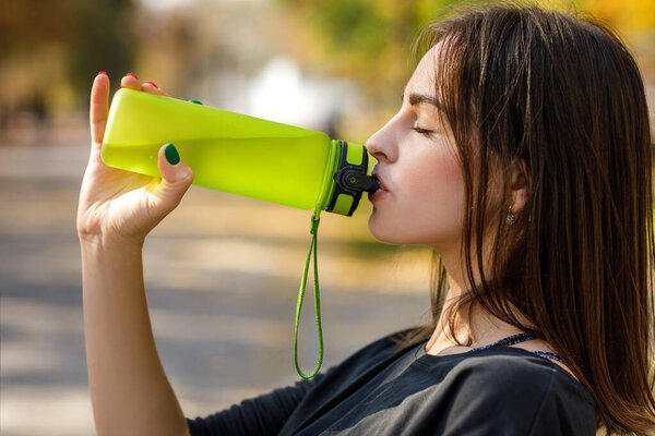 sporty woman drinking water