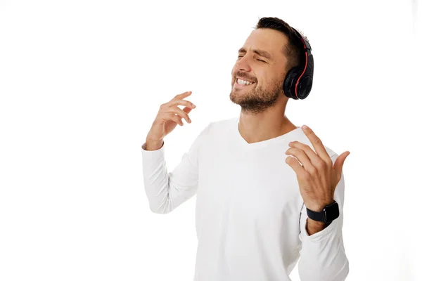 Mladý muž ve sluchátkách poslouchající hudbu — Stock fotografie