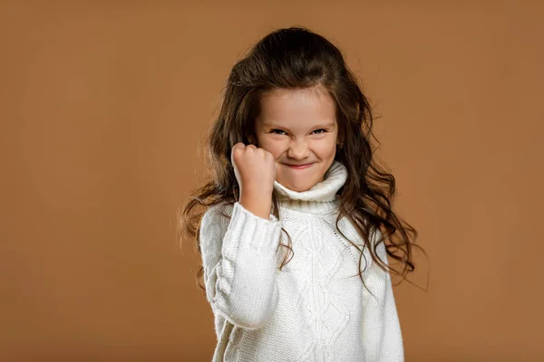 Злая кричащая маленькая девочка в белом свитере — стоковое фото