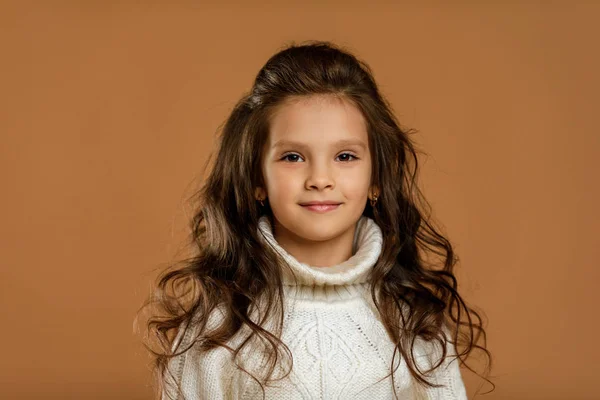 Маленька дівчинка в білому светрі дивиться на камеру — стокове фото