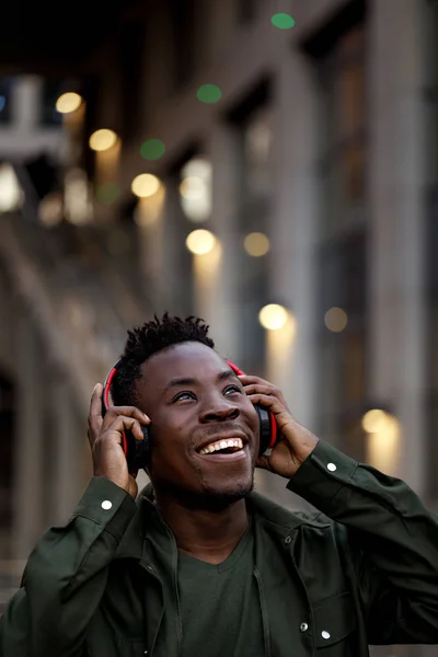 Hombre afroamericano en auriculares inalámbricos escuchando música — Foto de Stock