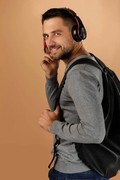 Kulaklık ve sırt çantalı yakışıklı genç adam. — Stok fotoğraf