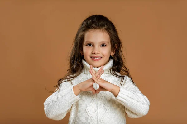 Szczęśliwy mały dziewczynka w biały sweter patrząc do kamery — Zdjęcie stockowe