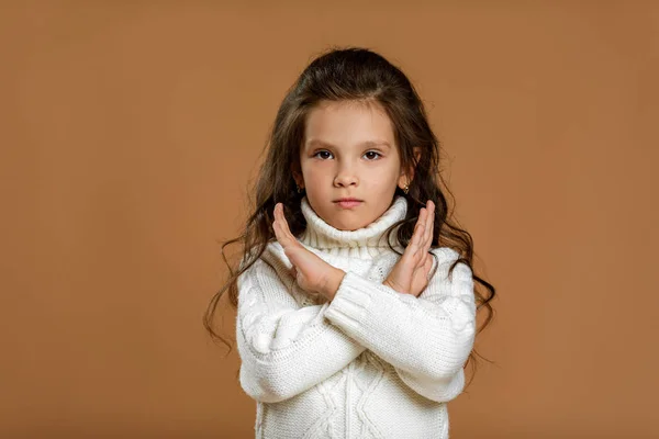 Mała dziewczynka w białym swetrze robi gest zatrzymania — Zdjęcie stockowe