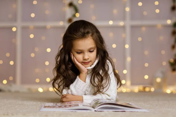 Barn flicka läser bok — Stockfoto