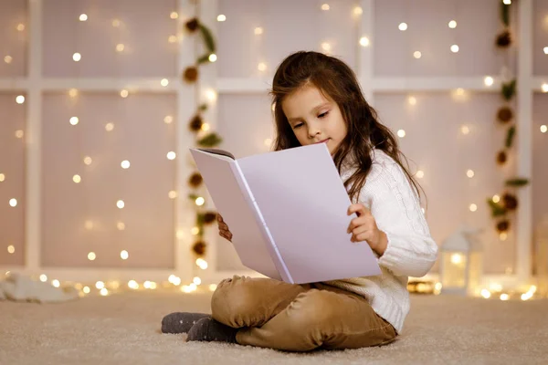 Criança menina está lendo livro — Fotografia de Stock