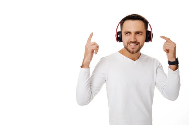 Kulaklıklı genç adam müzik dinliyor.