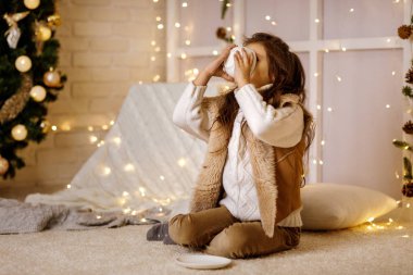 Sevimli küçük kız sıcak çikolata içiyor.