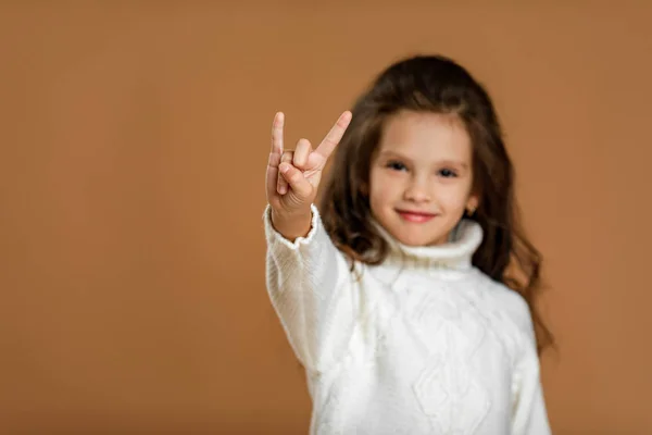 Bambina in maglione bianco che fa gesto Rock — Foto Stock