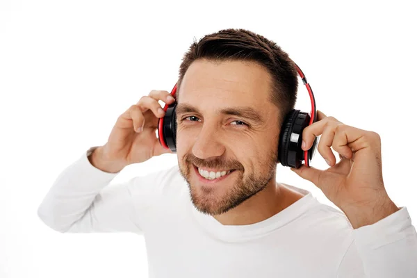 Mladý muž ve sluchátkách poslouchající hudbu — Stock fotografie