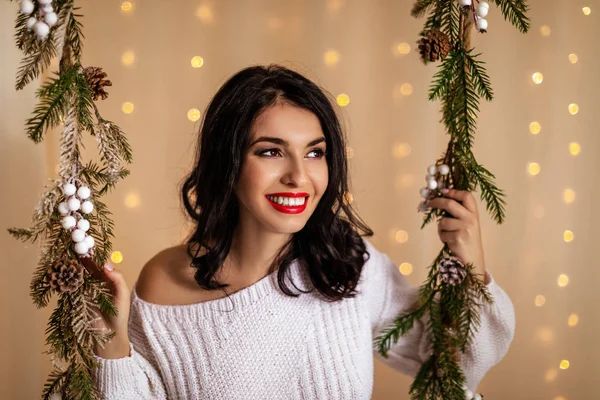 Mooie vrouw op swing met kerst decoraties — Stockfoto